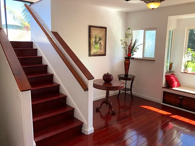 a view of a dining room with wooden floor and windows
