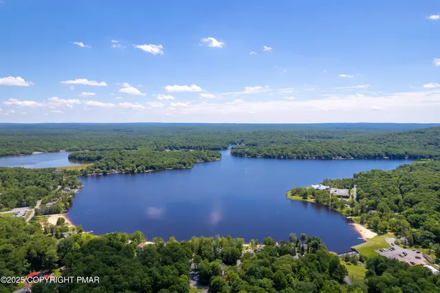 an aerial view of lake residential house with swimming pool and green space