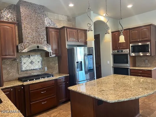 a kitchen with stainless steel appliances granite countertop a stove a sink and a microwave