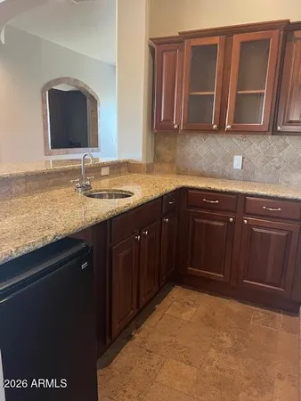 a kitchen with kitchen island granite countertop a sink a counter top space and stainless steel appliances