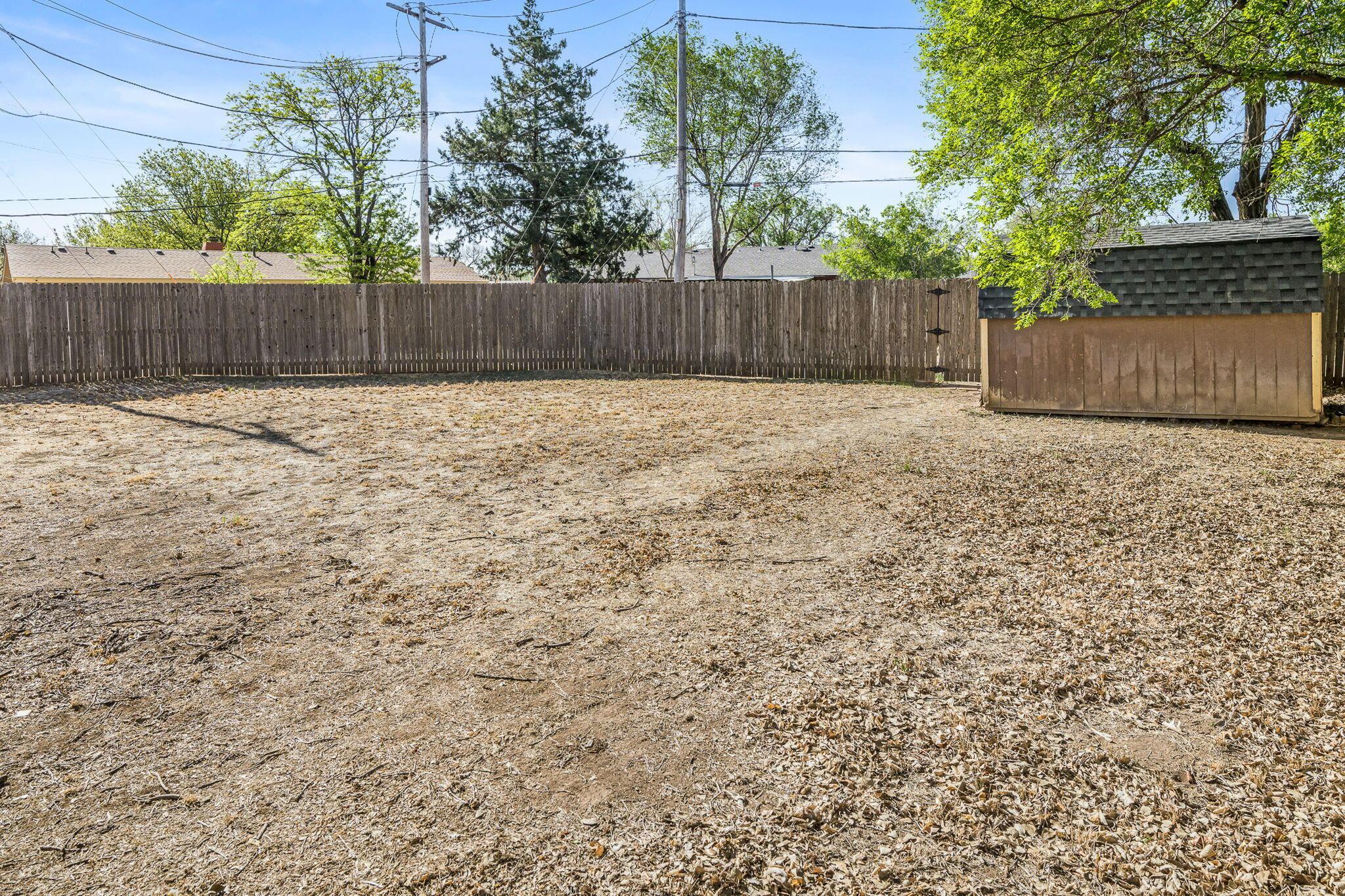 5305 Randolph Road Amarillo, TX 79106 - Photo 18 of 20 a view of a backyard with large trees and wooden fence
