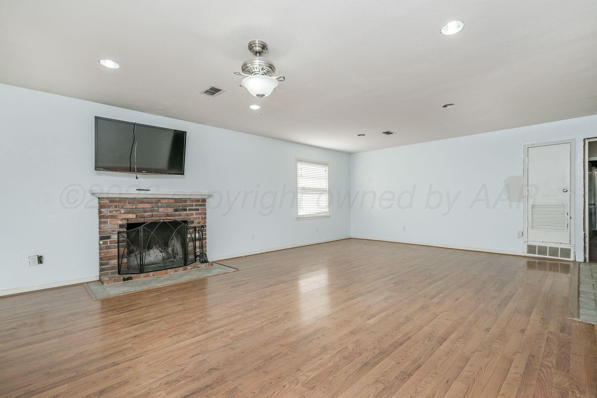 5305 Randolph Road Amarillo, TX 79106 - Photo 3 of 20 wooden floor fireplace and windows in an empty room
