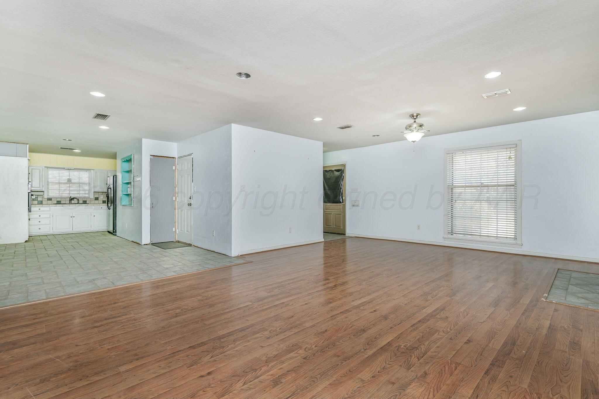 5305 Randolph Road Amarillo, TX 79106 - Photo 5 of 20 a view of an empty room with wooden floor and window