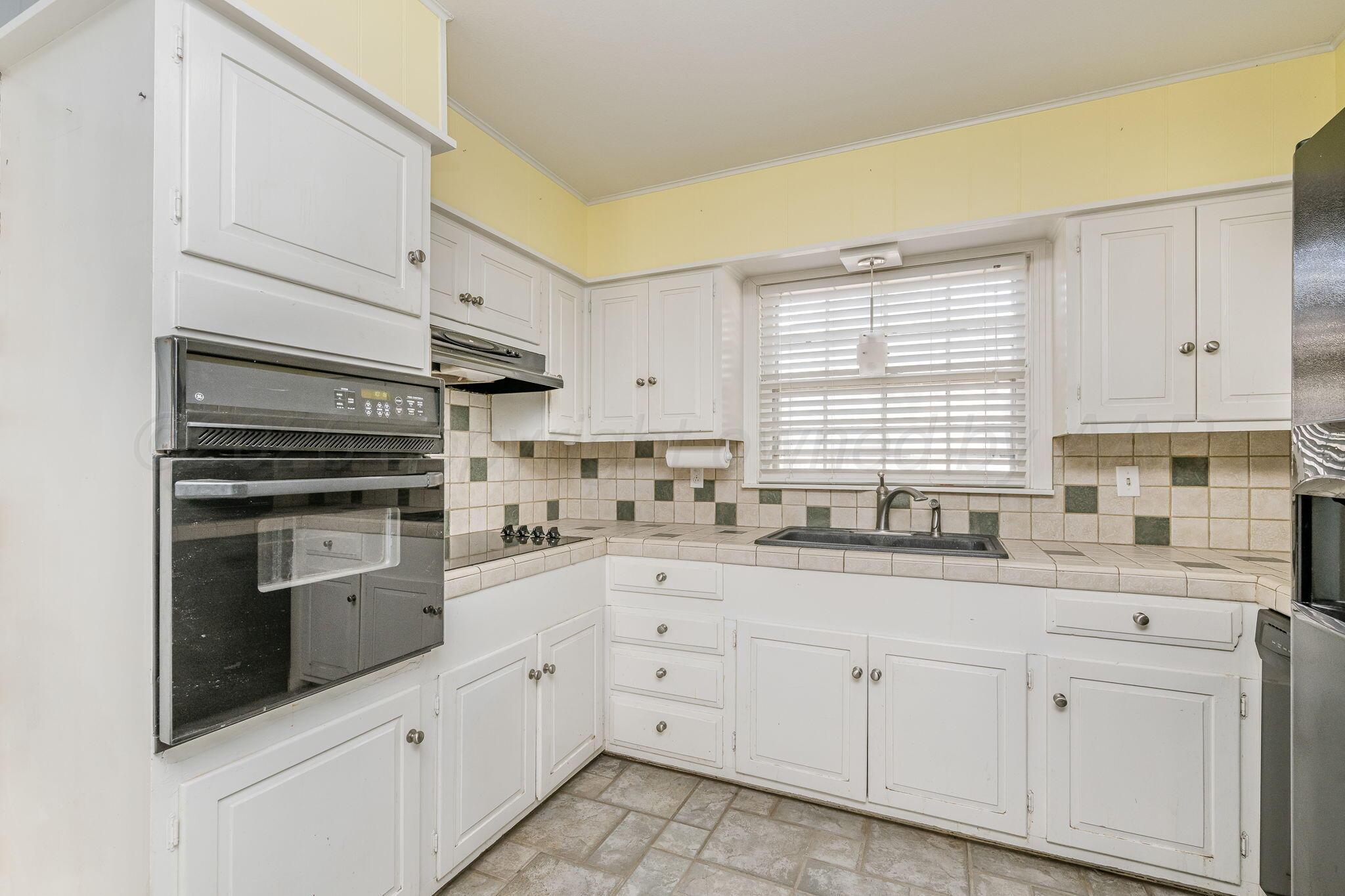 5305 Randolph Road Amarillo, TX 79106 - Photo 6 of 20 a kitchen with granite countertop white cabinets white stainless steel appliances with a sink and dishwasher