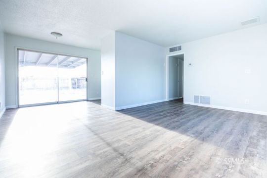 252 North Norma Street Ridgecrest, CA 93555 - Photo 3 of 18 an empty room with wooden floor and windows