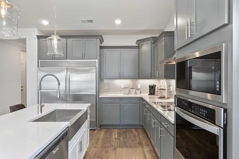 a kitchen with a sink stove top oven and refrigerator