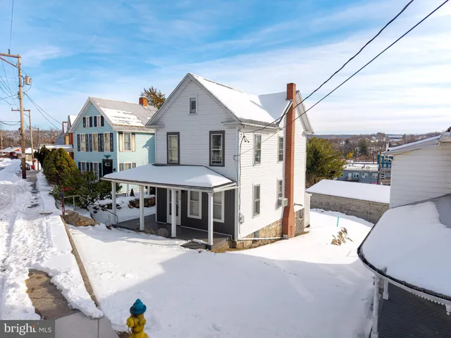a view of a patio with couches table and chairs and potted plants