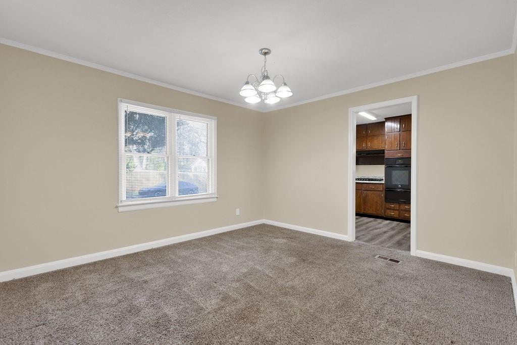 2739 Council Street Lithonia, GA 30058 - Photo 10 of 31 an empty room with chandelier fan and windows