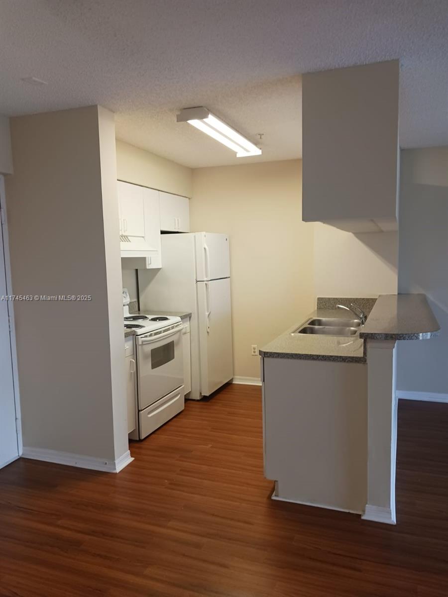 Pinehurst Club Condominiums Hollywood, FL 33021 - Photo 15 of 22 a kitchen with stainless steel appliances a white stove top oven and a refrigerator
