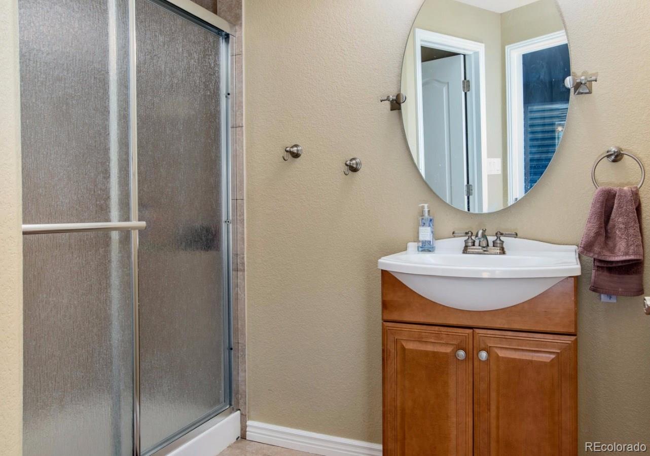 10685 Wynspire Road Highlands Ranch, CO 80130 - Photo 23 of 29 a bathroom with a sink vanity and a mirror