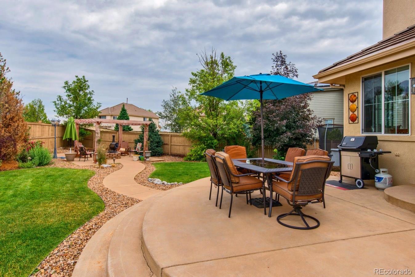 10685 Wynspire Road Highlands Ranch, CO 80130 - Photo 8 of 29 a backyard of a house with table and chairs