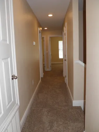 a view of a hallway with wooden shelves