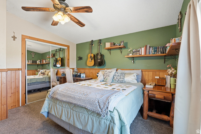 8066 North Valley View Heights Preston, ID 83263 - Photo 23 of 34 Room featuring wood paneling, a wood-finish ceiling fan, mirrored closet doors, and built-in wall shelving