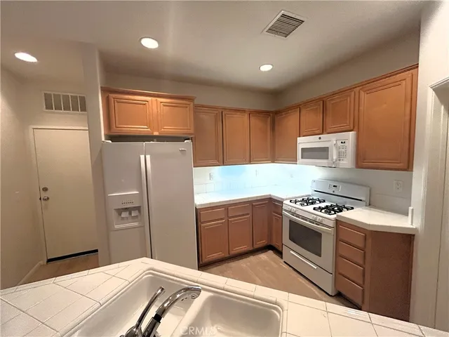 a kitchen with stainless steel appliances granite countertop a refrigerator stove and sink