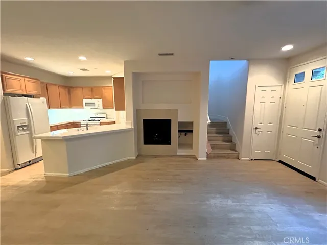 a view of a kitchen with refrigerator and a sink