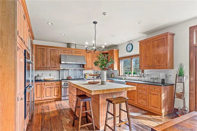 a kitchen with stainless steel appliances granite countertop a stove a sink dishwasher and cabinets with wooden floor