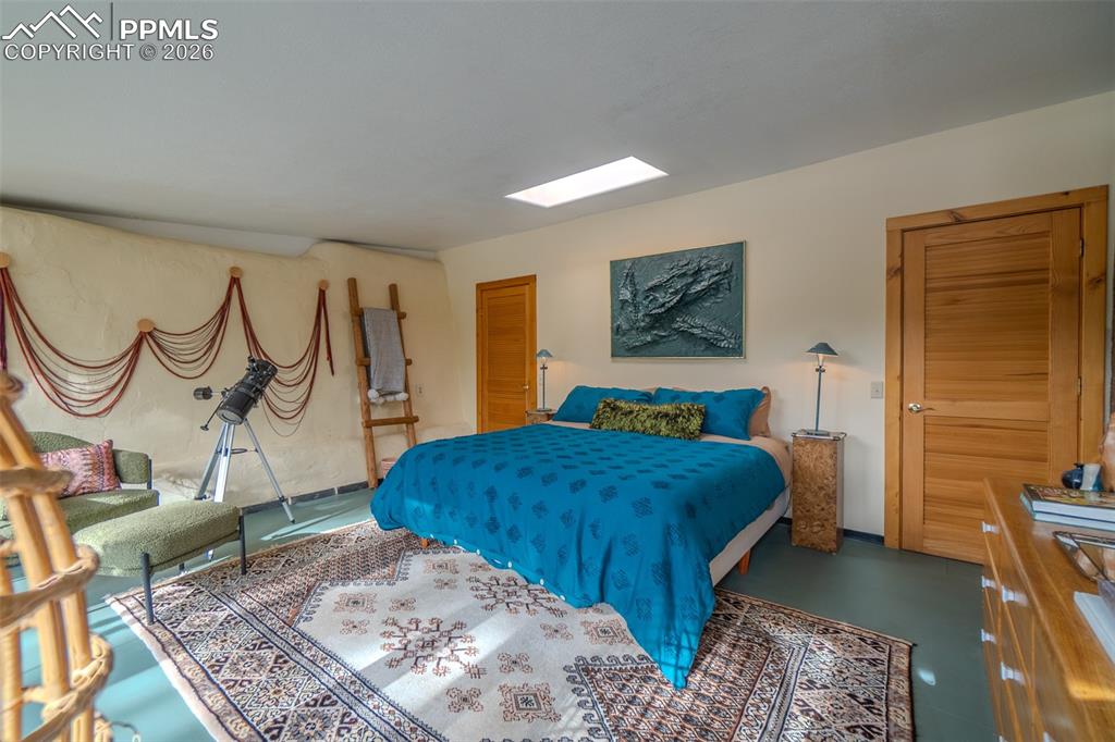 17160 Goshawk Road Colorado Springs, CO 80908 - Photo 25 of 43 a bedroom with a bed dresser and a window