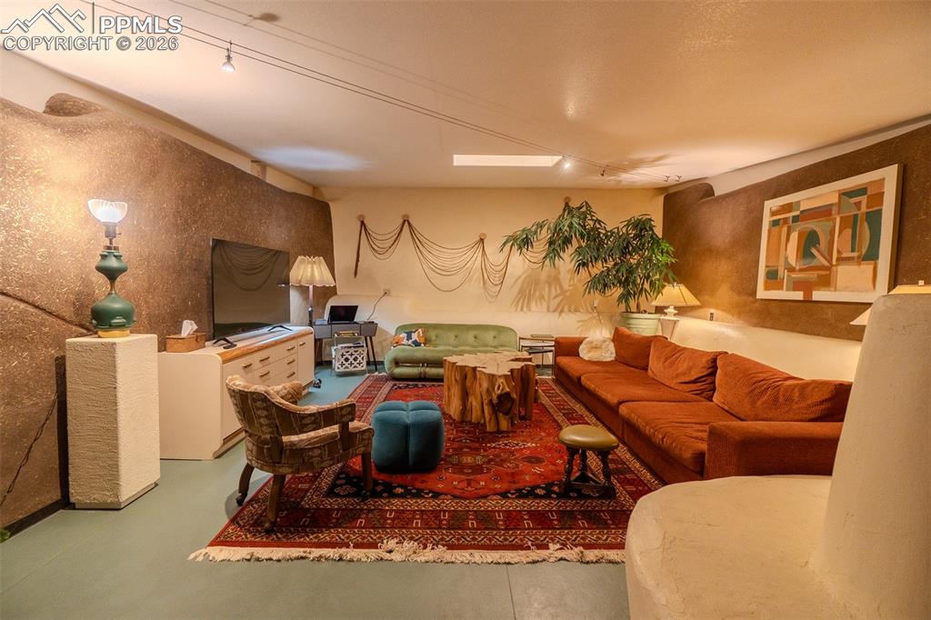 17160 Goshawk Road Colorado Springs, CO 80908 - Photo 9 of 43 a living room with furniture a flat screen tv and gym equipment