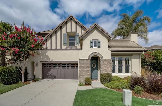a front view of a house with a garden and plants