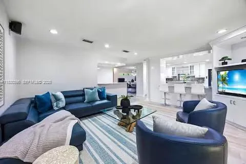 a kitchen with stainless steel appliances granite countertop table chairs sink and stove