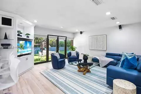 a kitchen with stainless steel appliances kitchen island granite countertop a stove top oven a sink a refrigerator and white cabinets