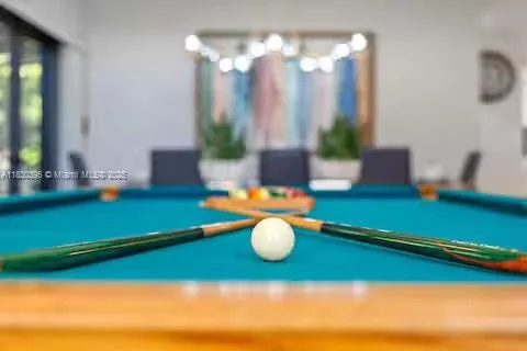 a room with pool table and windows