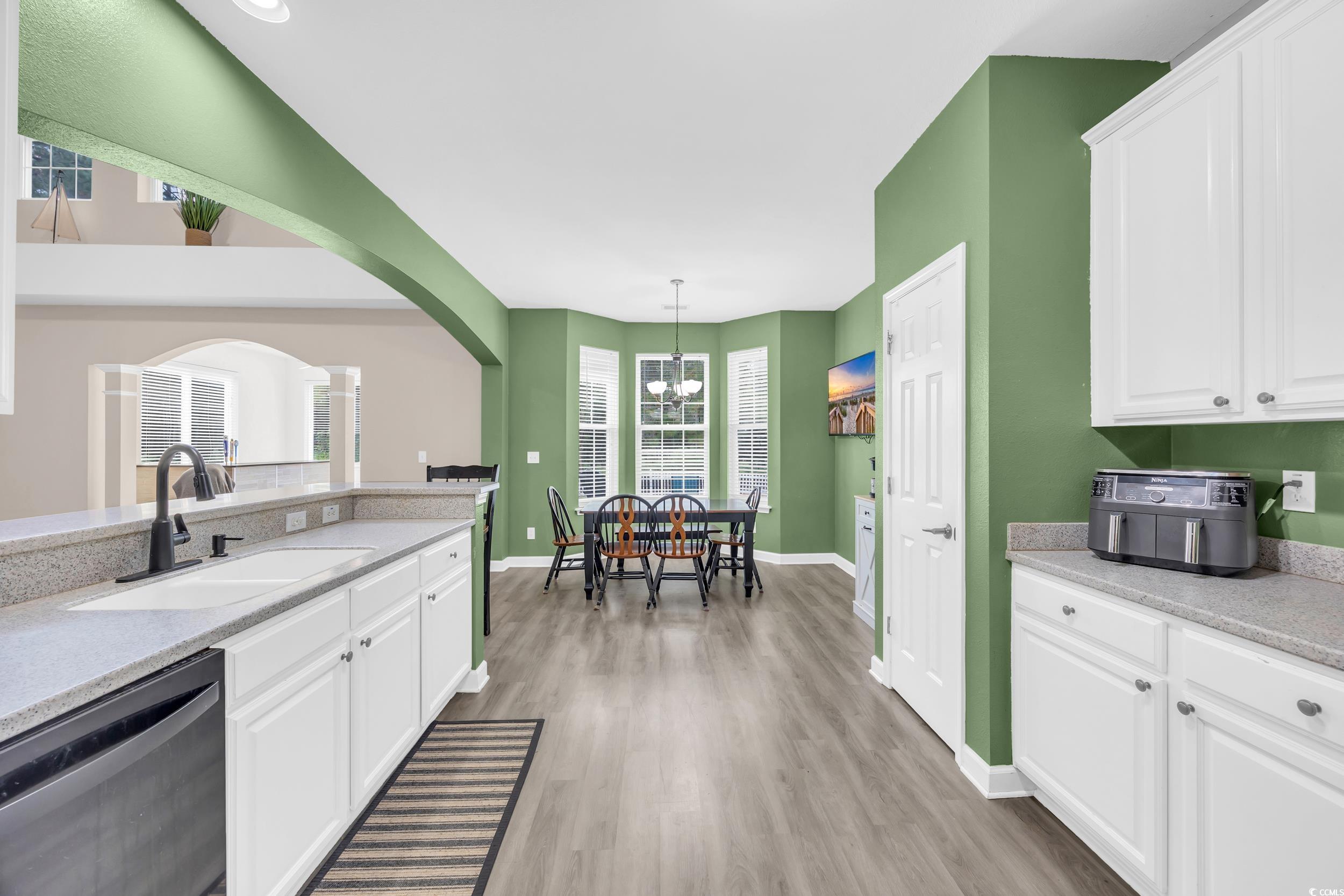 2352 Seneca Ridge Drive Myrtle Beach, SC 29579 - Photo 11 of 40 Kitchen featuring white cabinetry, dishwasher, light stone countertops, and arched walkways