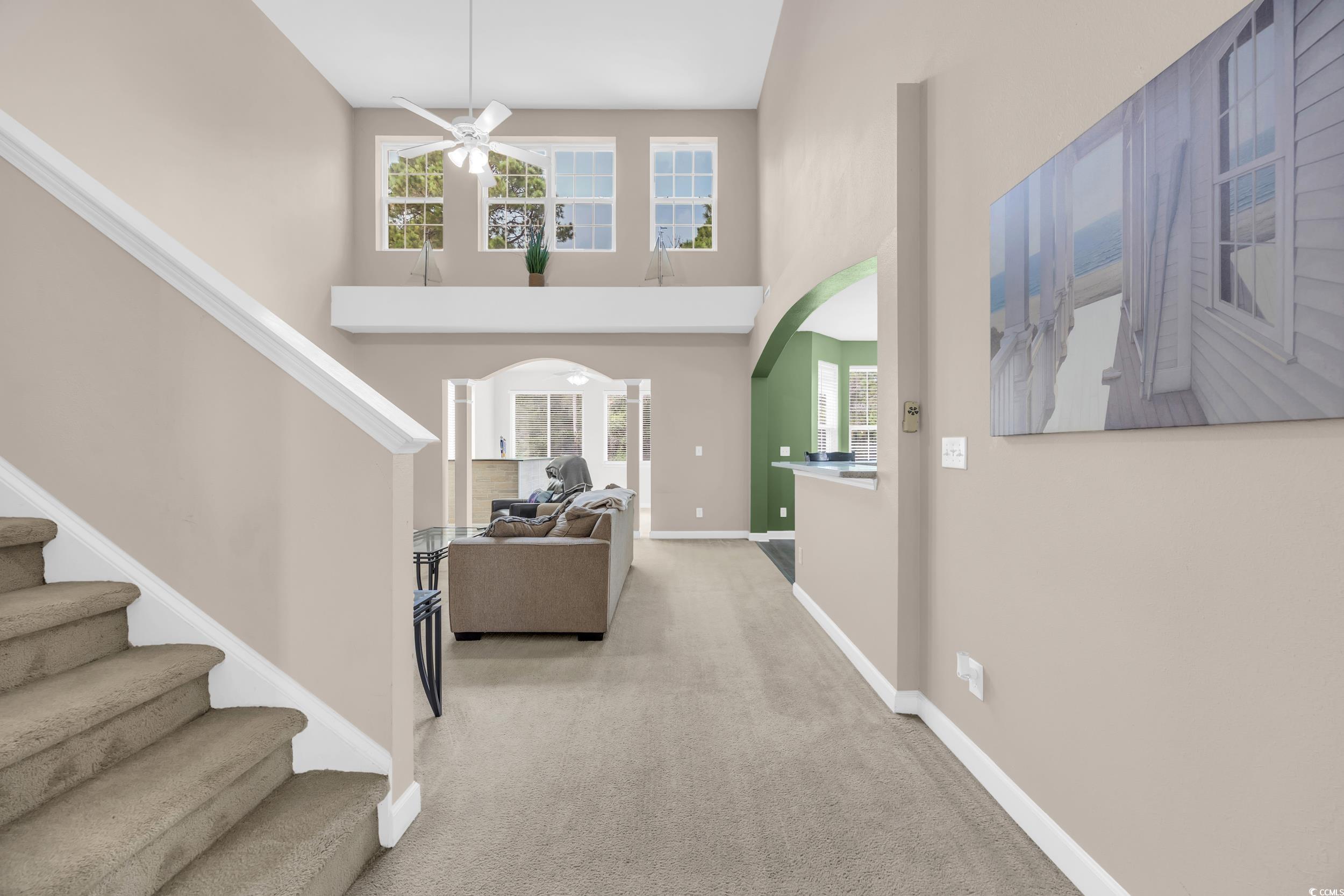 2352 Seneca Ridge Drive Myrtle Beach, SC 29579 - Photo 5 of 40 Foyer entrance with arched walkways, stairway, light colored carpet, a high ceiling, and a ceiling fan