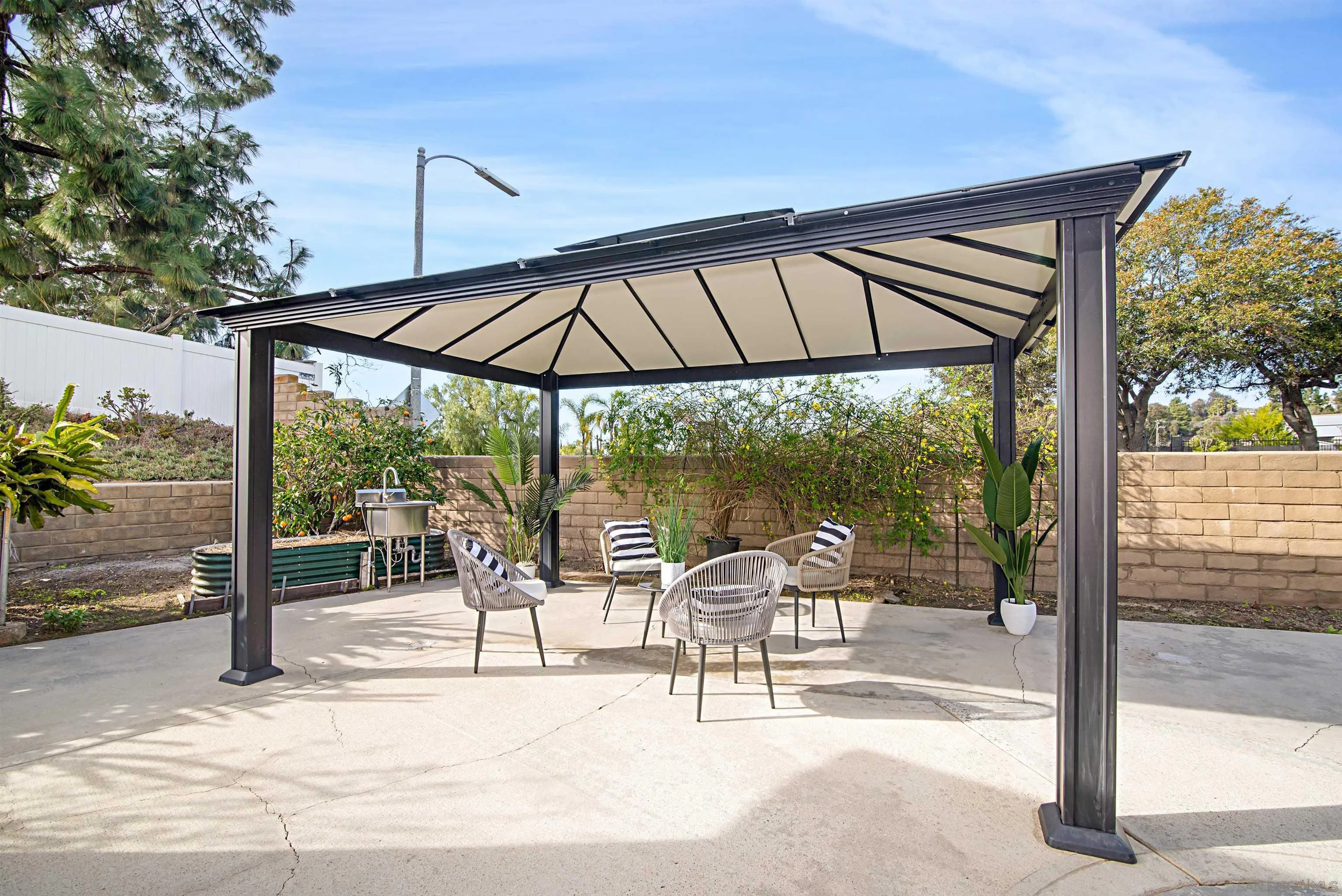 12866 Summerfield Lane Poway, CA 92064 - Photo 19 of 33 a patio with a table and chairs under an umbrella