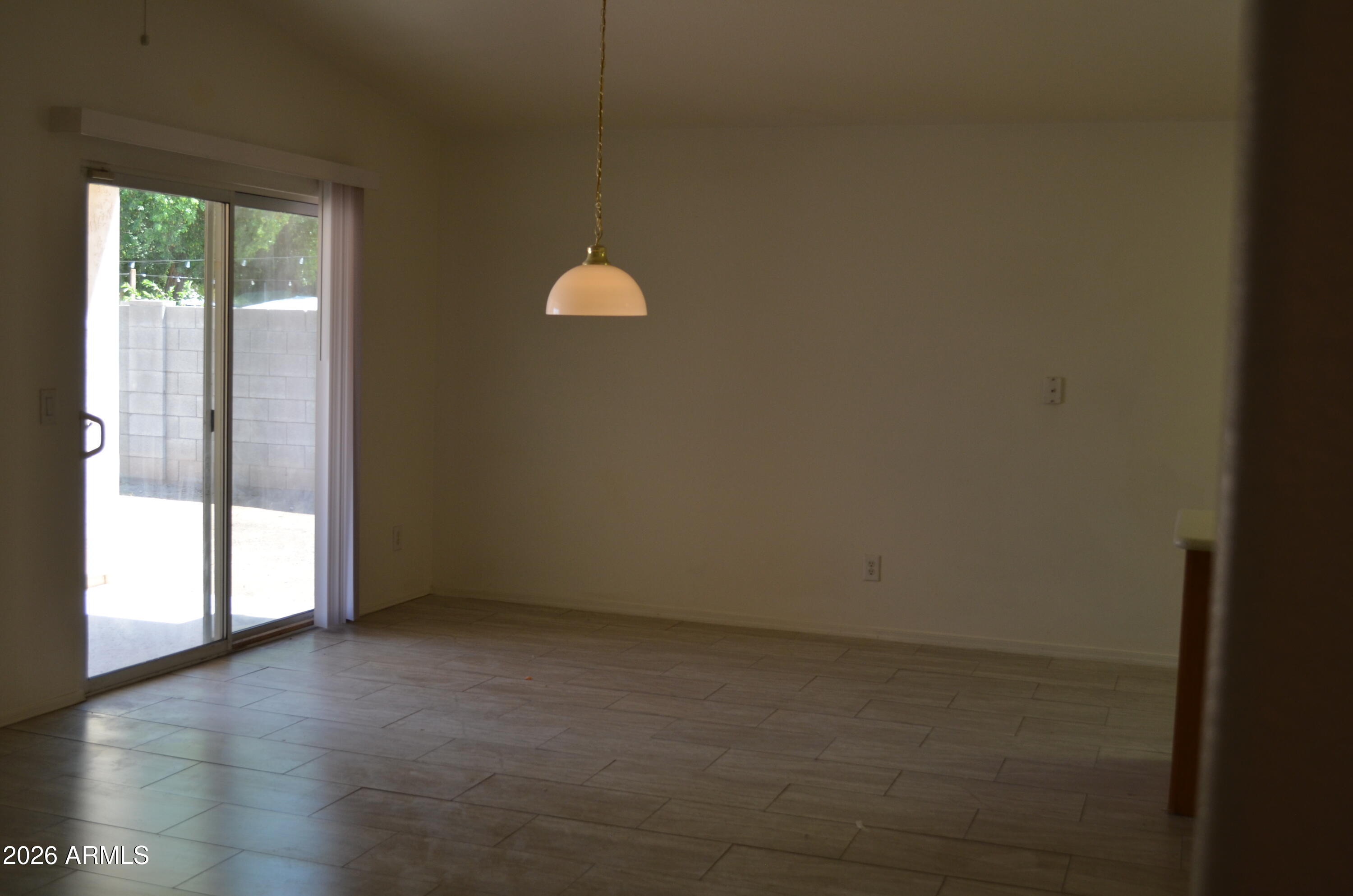 5409 South 11th Street Phoenix, AZ 85040 - Photo 7 of 17 a view of empty room with wooden floor and fan