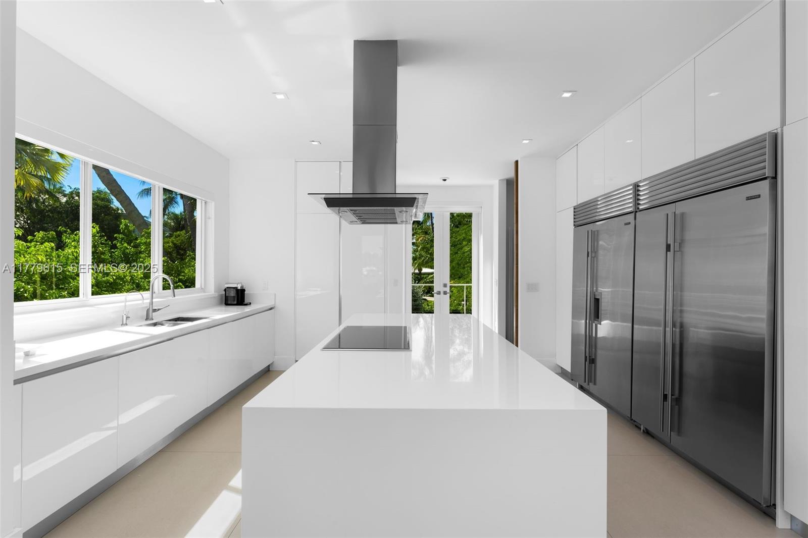 481 South Mashta Drive Key Biscayne, FL 33149 - Photo 15 of 57 a large white kitchen with a large window and stainless steel appliances