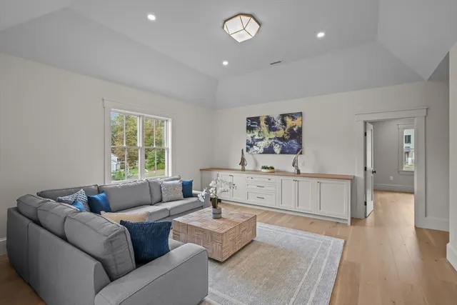 a living room with furniture wooden floor and a large window