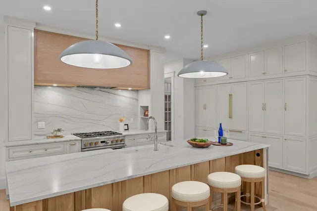 a kitchen with stainless steel appliances a dining table chairs and sink