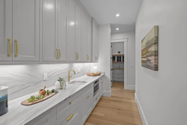 a hallway with sink and cabinets