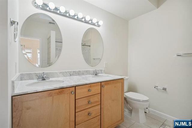 683 Main Street, Unit 2 Hackensack, NJ 07601 - Photo 13 of 15 a bathroom with a granite countertop toilet sink and mirror