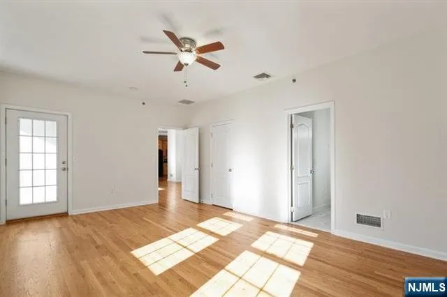 a view of a room with wooden floor and white walls