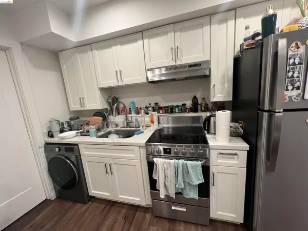 a kitchen with stainless steel appliances granite countertop a stove a refrigerator and a sink with wooden floor