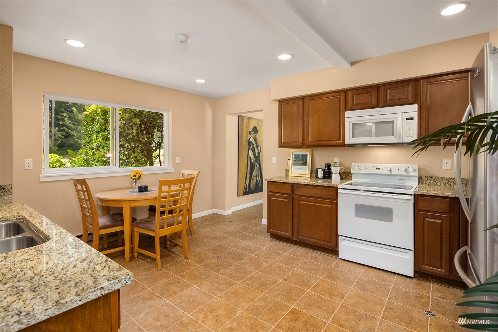 7382 View Park Road Southeast Port Orchard, WA 98367 - Photo 30 of 40 a kitchen with stainless steel appliances granite countertop a stove top oven a sink a dining table and chairs with wooden floor