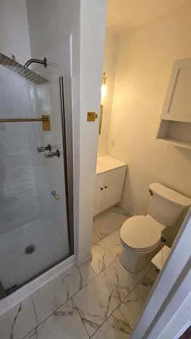 a bathroom with a toilet and a shower