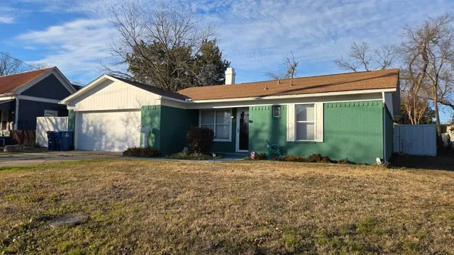 a front view of a house with a garden and yard