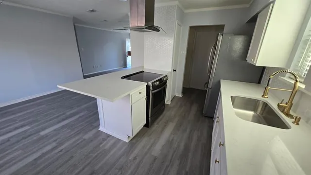 a kitchen with granite countertop a sink a refrigerator and wooden floor