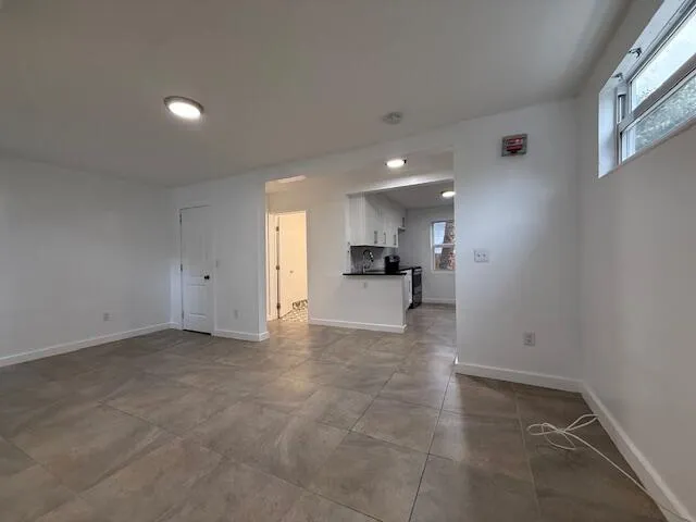a view of kitchen with refrigerator and window