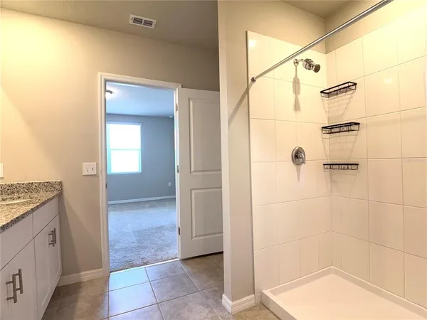 a bathroom with a granite countertop shower a mirror and a sink