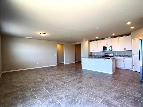 a large kitchen with granite countertop a stove a sink and a granite counter tops