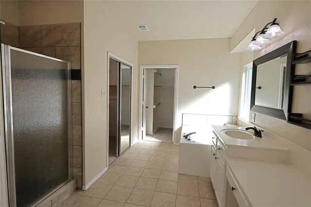 a spacious bathroom with a double vanity sink a mirror and a shower