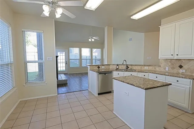 a kitchen with granite countertop a sink stove and refrigerator