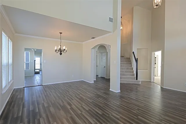 an empty room with wooden floor and staircase