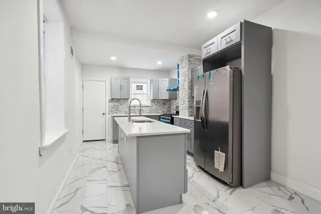 a kitchen with stainless steel appliances granite countertop a refrigerator a sink and a stove