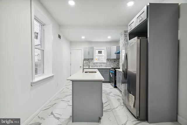 a kitchen with stainless steel appliances a refrigerator sink and microwave