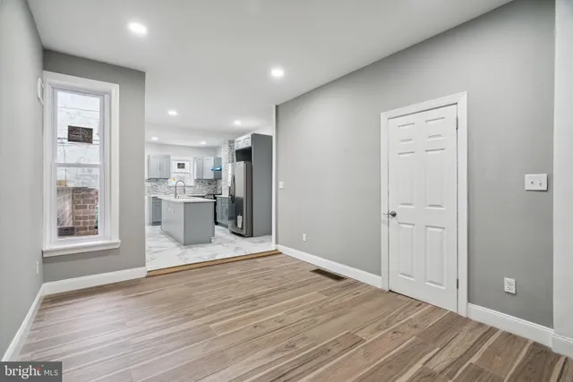 a view of kitchen with refrigerator cabinets and wooden floor